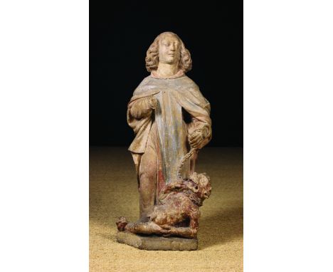 A 15th/16th Century Stone Carving of Saint Michael depicted with shoulder length curly hair wearing a cloak draped over a lon