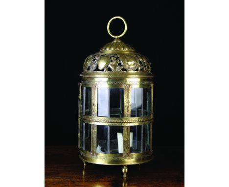 A Good 18th Century Pierced Sheet Brass Lantern with repoussé decoration. The cylindrical body with leaded glass sides in a f