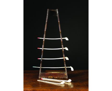 A Collection of Clay Pipes on an oak A-frame pipe rack with trough base, 30 ins (76 cms) high, 12 ins (30.5 cms) wide.
