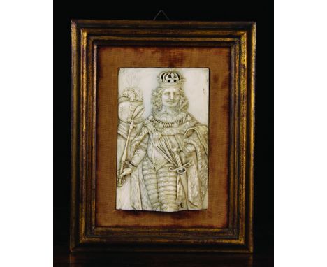 A 17th/18th Century Ivory Plaquette intricately carved with a three quarter length portrait of a King, 5½ ins x 3½ ins (14 cm