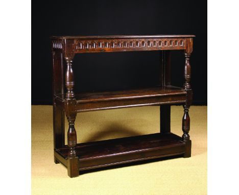 A 17th Century & Later Three Tier Oak Buffet. The top with moulded edge above a nulled frieze raised on baluster turned posts