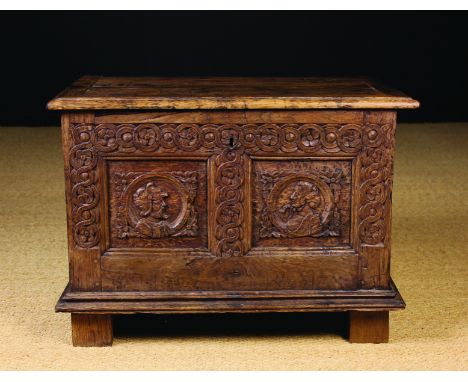 A Small 16th Century & Later Oak Coffer with Carved Romayne Panels.  The planked lid on iron loop hinges. The front carved wi