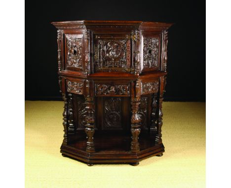 A Carved 16th Century Renaissance Style Dressoir dated 1737. The canted cupboard enriched with carved portrait heads amidst s