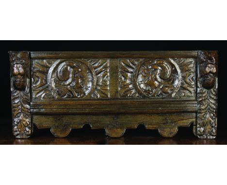 An Elm Wall Rail carved with a pair of Romayne portrait roundels amidst foliage above an applied moulding strip and shaped un