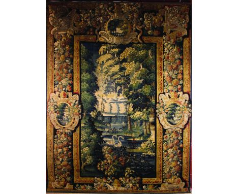 A 17th Century Aubusson Verdure Tapestry. The leafy landscape featuring a pair of swans on a lake to the centre, with a parro
