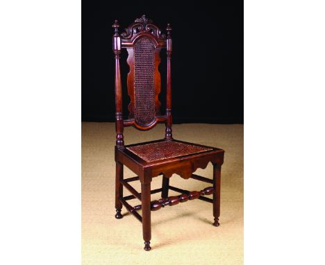 An Early 18th Century Cherrywood Side Chair.  The pierced and carved cresting rail above a caned back and seat flanked by tur