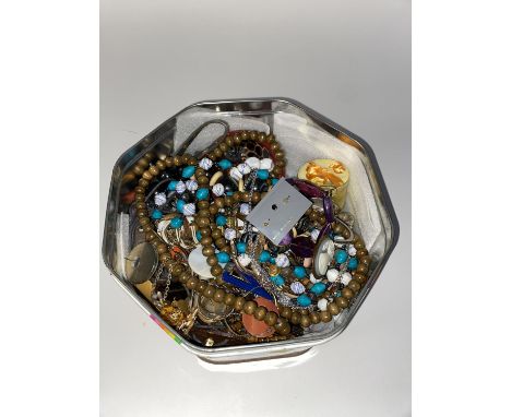 A tin of assorted costume jewellery, including beaded necklaces