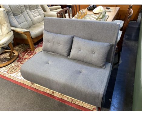 A grey fold out bed settee