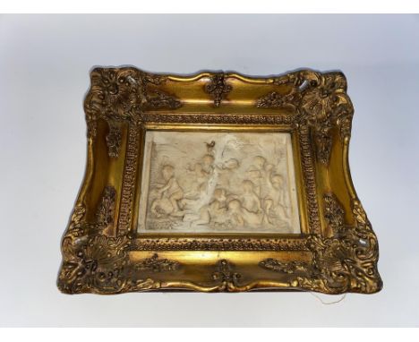 A 19th Century Continental alabaster plaque depicting putti, the reverse having a coin set to the centre, framed, possibly by