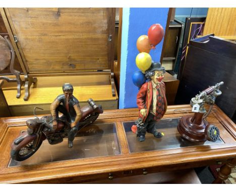 A vintage wooden sculpture of a Harley Davidson motorcycle and rider, a painted clown ornament and a reproduction mahogany te