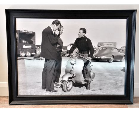 Stirling Moss on His Vespa'A large format true-photographic monochrome print depicting Stirling Moss on his Vespa paddock sco