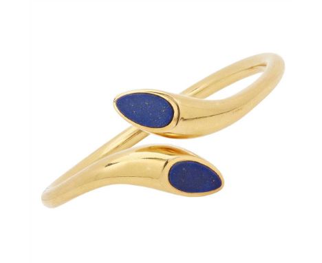 A 1970s lapis lazuli set bangle of hinged torque form, the teardrop shaped terminals set with a plaque of lapis lazuli, stamp