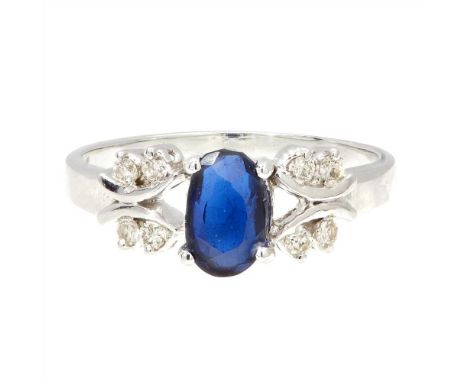 A sapphire and diamond set cluster ring claw set with an oval-cut sapphire, each shoulder set with four small round-brilliant