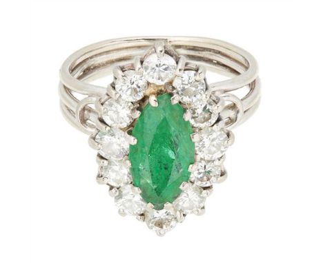 An emerald and diamond cluster ring claw set with a marquise cut emerald within a surround of twelve round brilliant cut diam