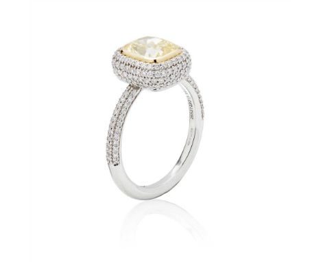 A platinum yellow and colourless diamond ring, Tiffany &amp; Co collet set with a cushion cut yellow diamond, in a pavé set s