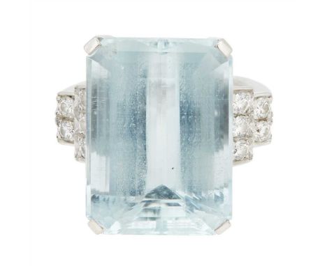 An aquamarine and diamond set ring claw set with an emerald cut aquamarine flanked by two tiers pavé set with round brilliant