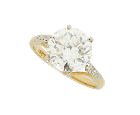 A single stone diamond ring claw set with a round brilliant cut diamond to shoulders partially pavé set with diamonds, the pl