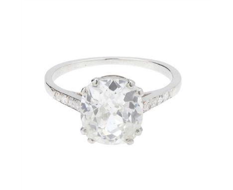 An early 20th century single stone diamond ring claw set with a cushion cut diamond, each shoulder set with four eight-cut di