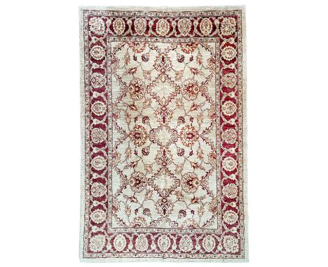 A Ziegler design Chobi carpet. The ivory field with an all over design of large palmettes and leafy vines, within a madder sc
