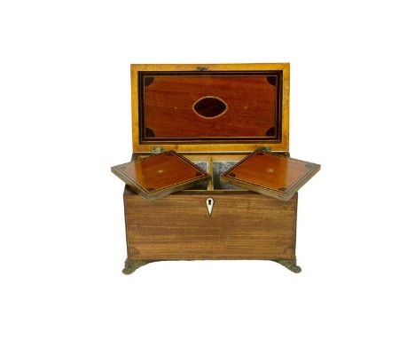 A George III mahogany, inlaid, and crossbanded tea caddy. Fitted two lidded compartments, on stamped brass paw feet, height 1