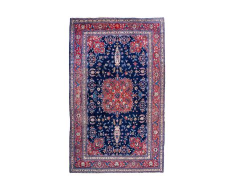 A Tabriz carpet, North West Persia, circa 1920. With signature cartouche, the indigo field with a central madder lobed pole m