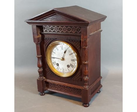 A late Victorian walnut cased mantle clock, the dial with Roman numerals and with two train movement, 33cms tall 