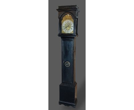 An ebonised longcase clock, the arched hood above a rectangular door and conforming plinth base, the brass dial inscribed Tho