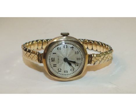 A ladies 9ct-gold-cased wrist watch by Buren, on plated expanding bracelet.