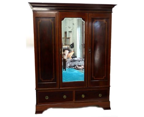 An Edwardian mahogany satinwood cross banded wardrobe, the central mirrored panel flanked by two panelled doors, above two fr