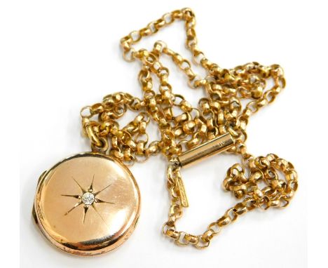 A pendant and chain, the circular portrait pendant set with single tiny white stone in a gold plated backing, on a belcher li
