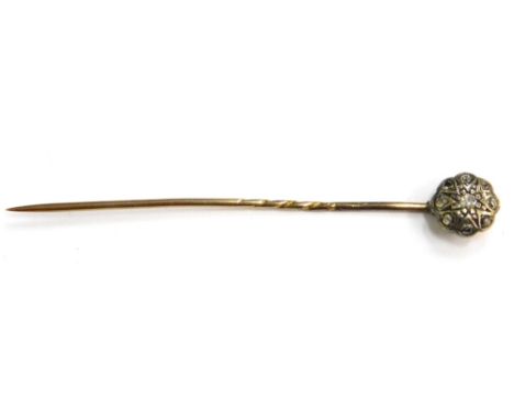 A Victorian diamond set stick pin, with small circular flower design head, on a yellow metal pin, unmarked, 6cm long, 1.6g al