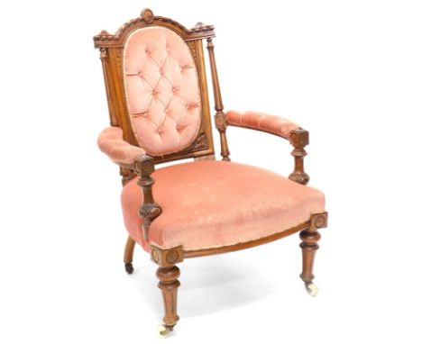 A Victorian walnut open armchair, the shaped back carved with ribbons, patera, etc., on fluted supports, with buttoned back a