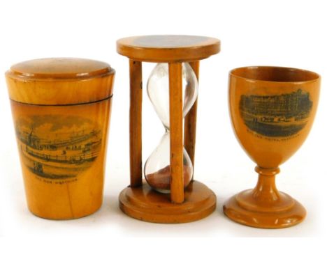 An early 20thC Mauchline ware sycamore egg timer, with Shanklin scene, 9cm high,  a Queens Hotel Hastings egg cup and the Pie