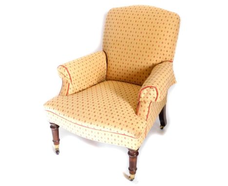 A Victorian style mahogany armchair, upholstered in gold and red fabric, with piped borders, on turned tapering legs, with ce
