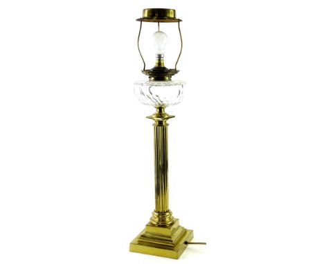An early 20thC brass oil lamp, with cut glass reservoir on a reeded stem, terminating in a stepped square base with later ele