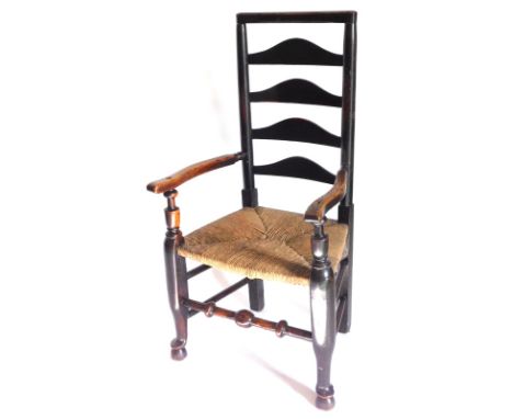 A 19thC ash and elm ladder back armchair, with shaped arms and a rush seat, on part turned legs with pad feet, etc. 