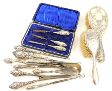 A collection of silver mounted dressing table items, to include two brushes, shoe horns, button hooks, glove stretchers, etc.