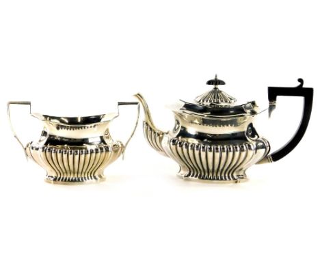 An Edwardian rectangular silver teapot, with rounded corners and part fluted decoration, on an ebonised knop and handle and a