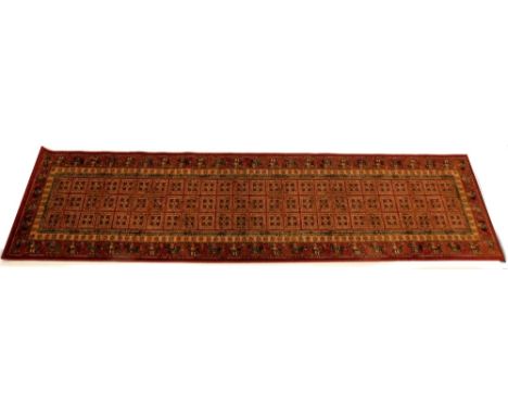 A Belgian cotton Persian style runner, with a design of roundels within squares on a red ground, retailed by John Lewis, 67cm