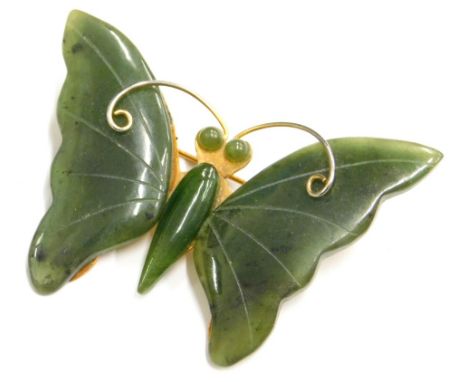 A jade set butterfly brooch, with two jade wings, body and eyes, on a gold plated frame, 4cm wide.