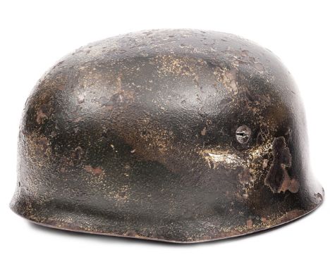 A Third Reich parachutist’s helmet,  with roughened dark green and tan camouflage, traces of Luftwaffe eagle decal, and late 
