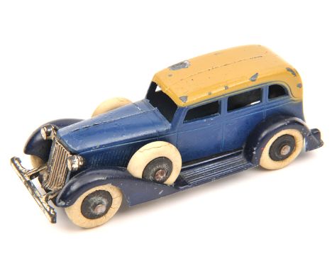 A Tootsietoy Graham saloon. In dark blue with beige roof and black wheels. White tyres to road wheels and two spare wheels. G