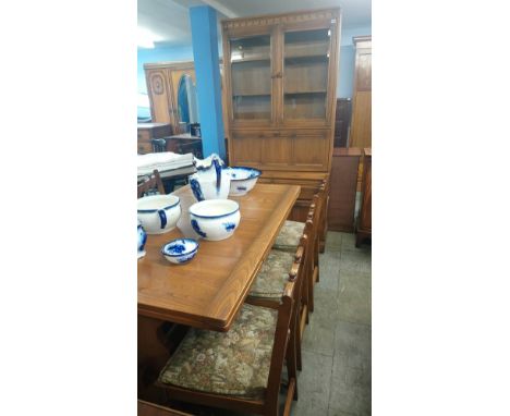 An Ercol drawer leaf table and six chairs and a cabinet