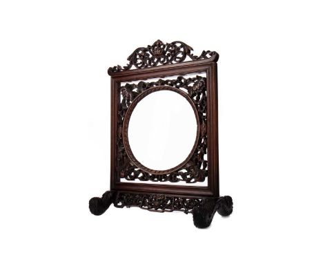 CHINESE HARDWOOD SCHOLAR'S TABLE MAGNIFYING GLASS,19th century, the frame carved and pierced with lotus scrolls, on swept sup