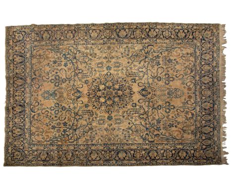 A large antique "Country House" Mahal carpet with a faded ivory ground with a central boss and open corners, the ground with 