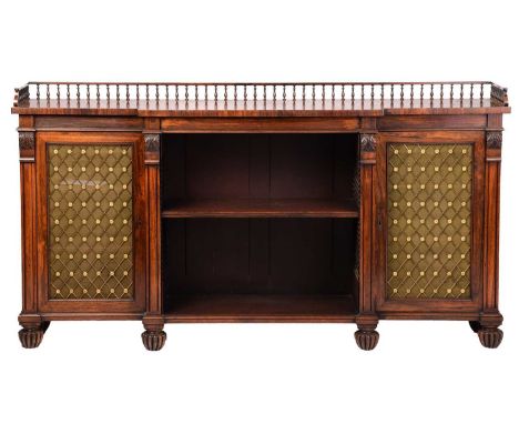 A Regency rosewood sideboard, the galleried top over a central shelved recess, flanked by two cupboard doors, on reeded bun f