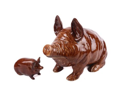A large Wemyss Ware pig, naturalistically modelled seated upon its haunches in treacle glaze, 27 cm high x 45 cm long, togeth