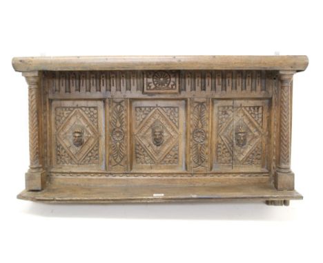 17th century and later carved oak overmantel with three mask boss lozenge panels and shelf below, 108cm wide x 22cm deep x 59