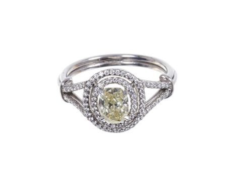 Diamond double-halo cluster ring with a natural fancy yellow oval brilliant cut diamond weighing 1.06cts, surrounded by brill