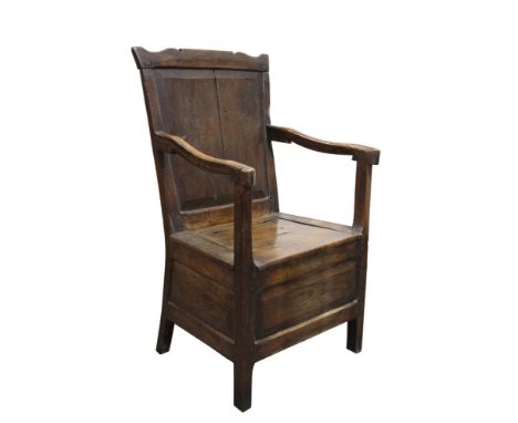 Mid-18th century Welsh oak commode chair, the panel back with undulating top rail and hinged solid seat on field panel frieze